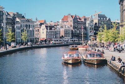 boats on the river near the building amsterdam google meet background