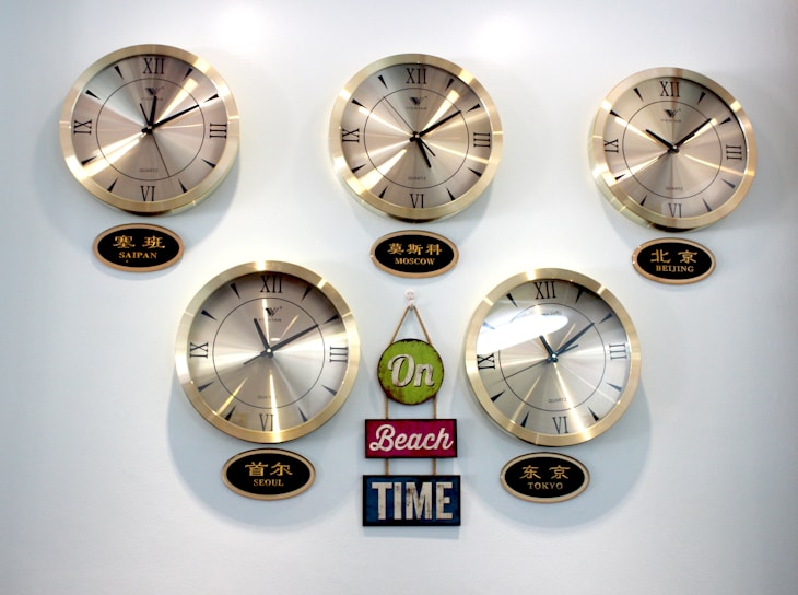 A cartoon showing a politician juggling clocks labeled with different time zones, symbolizing political promises across the globe.