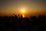 Guests enjoying a sunset cocktail on the terrace with panoramic ocean views.