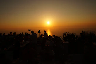 Evening view of Lo Balconet terrace with warm lights and guests enjoying cocktails