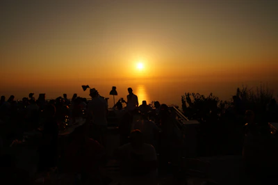 Evening view of Lo Balconet terrace with warm lights and guests enjoying cocktails