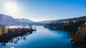 A serene lakefront home bathed in warm sunlight, reflecting peaceful waters.