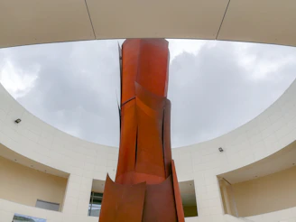 Visitors admiring a striking sculpture made of reclaimed metal in an open courtyard