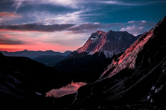 mountains with fog under blue and orange sky in Seebensee Austria