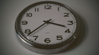round silver wall clock at 3:38