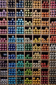 A vibrant display of colorful paint cans arranged on wooden shelves in a cozy store setting