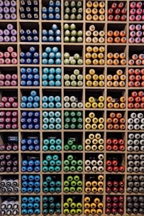 A vibrant display of colorful paint cans arranged neatly, showcasing reds, yellows, and whites.