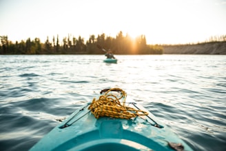 person silhouette photo of person on-board in green kayak near other person in green kayak