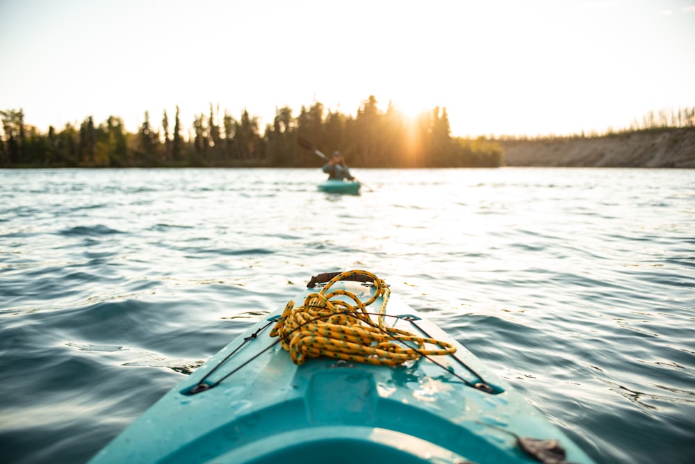 person silhouette photo of person on-board in green kayak near other person in green kayak