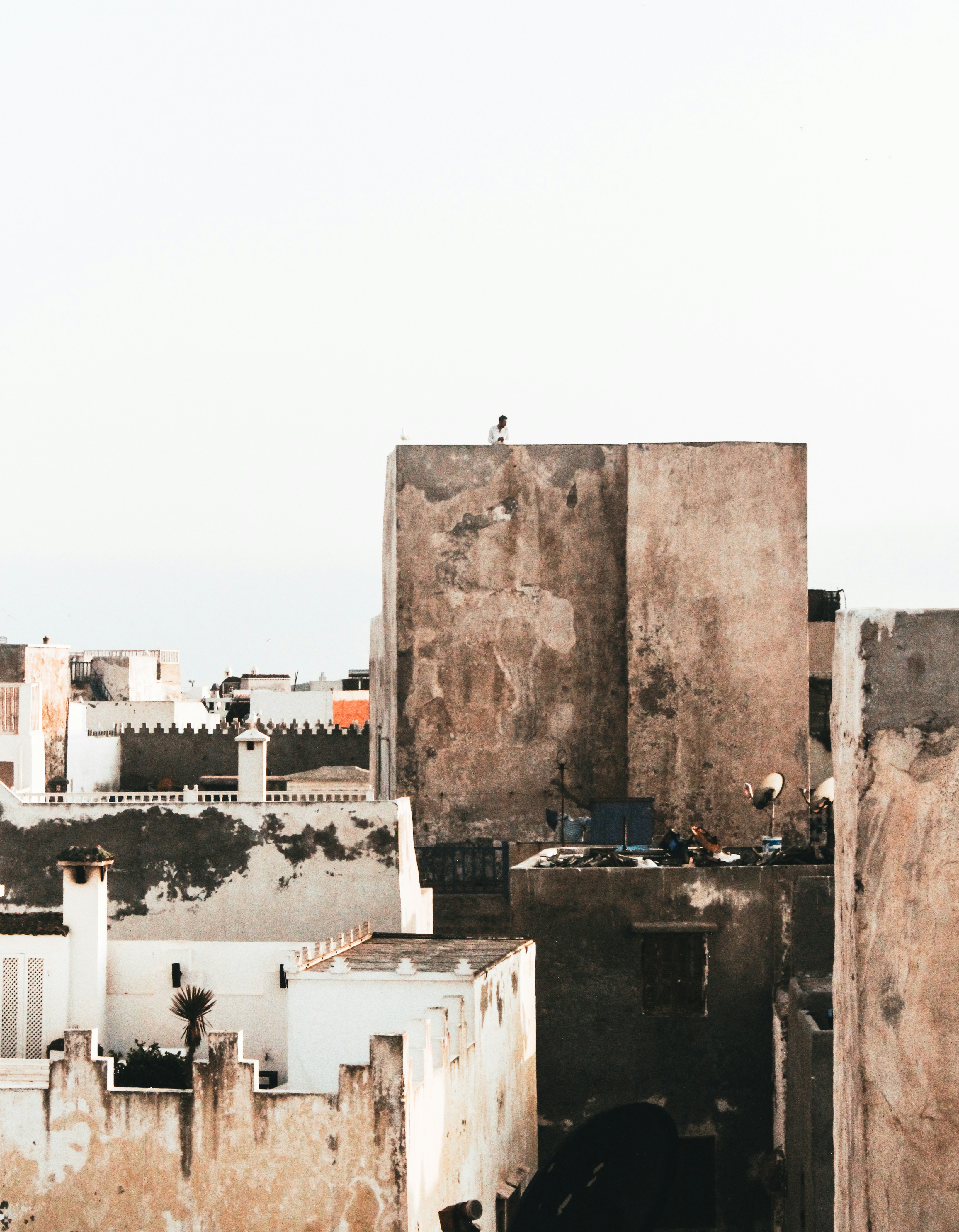 Person doing yoga on a rooftop terrace at sunrise with a panoramic view of a golden-lit ancient city below