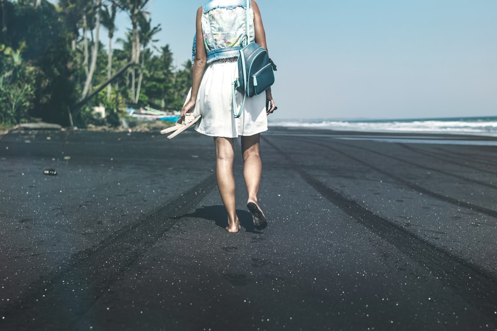 woman walking on the seashore during daytime