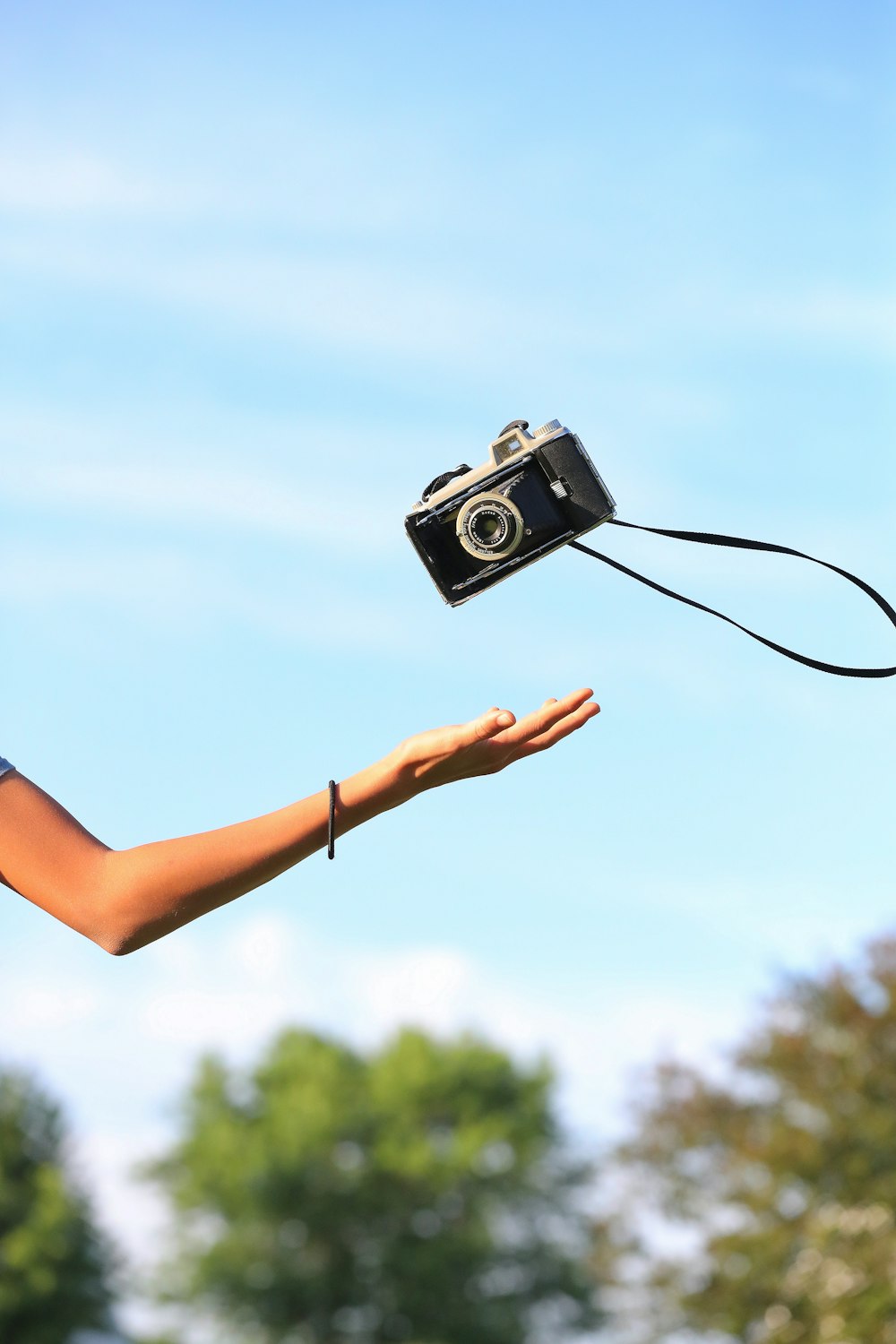 person catching black film camera during daytime