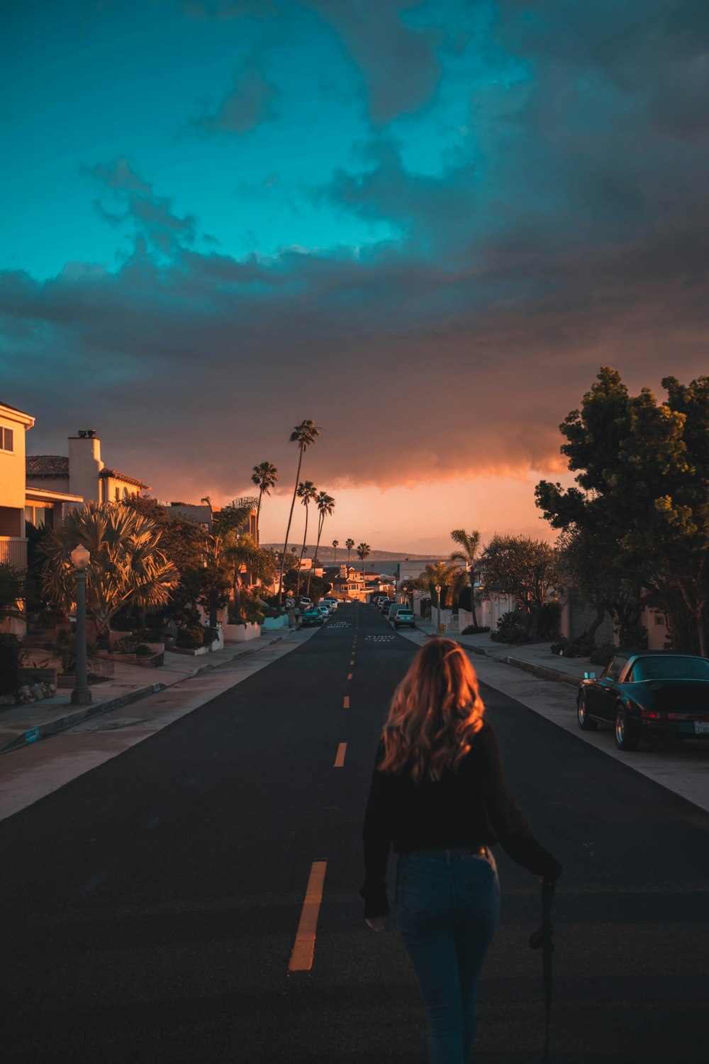 woman walking on grey and yellow asphalt road