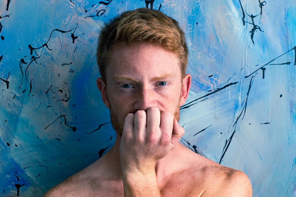 man holding his chin with abstract painting background