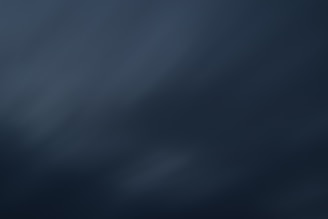 A dark, abstract gradient with smooth transitions between shades of deep blue and gray.