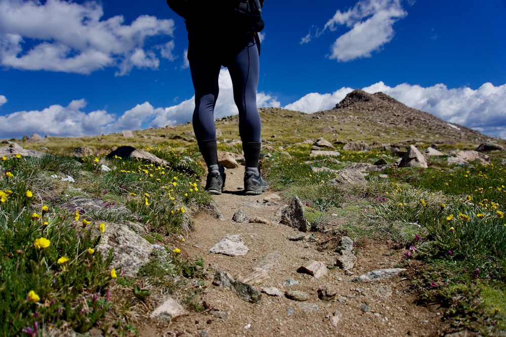 person standing on brown soil near flowers