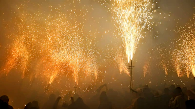 A family enjoying a backyard celebration with small fireworks illuminating their smiles.