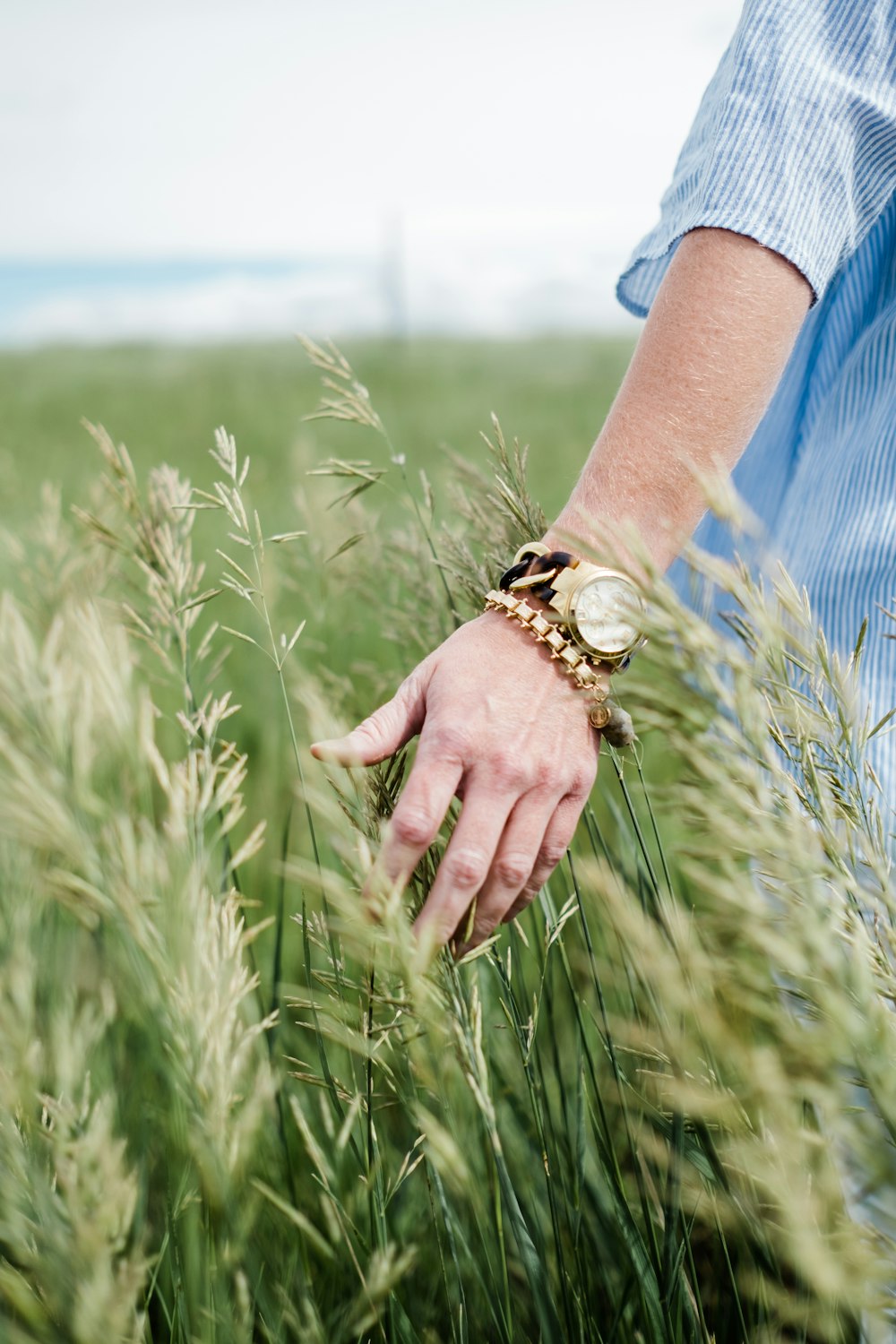 Persona que lleva reloj analógico de color dorado con pulsera de eslabones