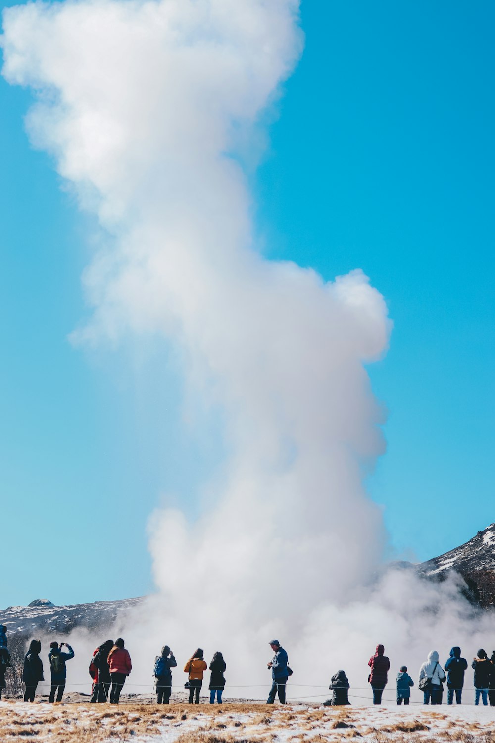 group of people in front of geyser