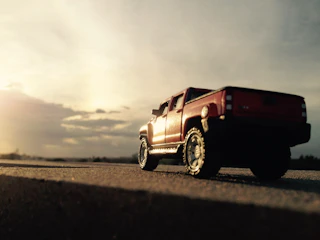 White pickup truck on a rural road during sunset.