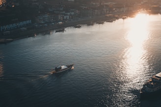 A serene view of the Ganges river at sunrise with boats gently floating near the ghats in Varanasi.