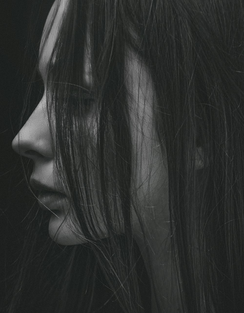grayscale photo of woman's left side face covered with hair