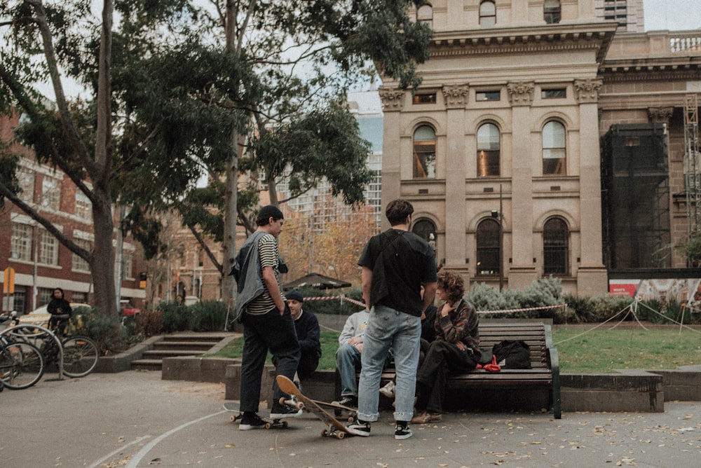 people on bench near brown building