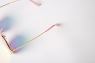 Ivory-colored eyeglass frames arranged on a black velvet surface with subtle golden highlights.