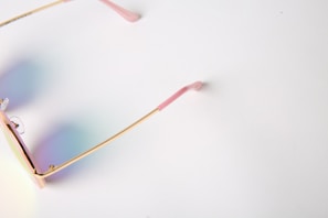 Elegant women's eyeglasses with subtle gold accents displayed on a soft fabric background.