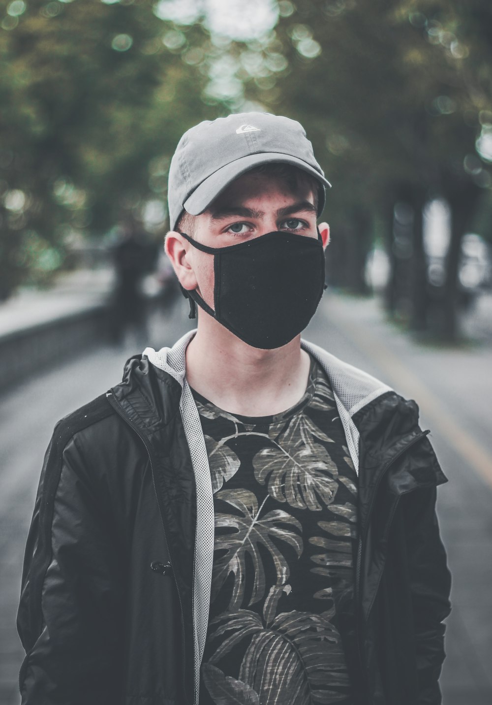 Hombre con mascarilla negra en el parque durante el día