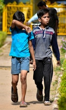A group of boys wearing stylish casual clothes walking outdoors on a sunny day.