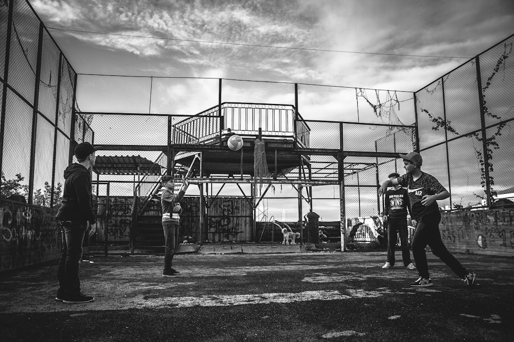 Foto en escala de grises de un grupo de niños jugando béisbol