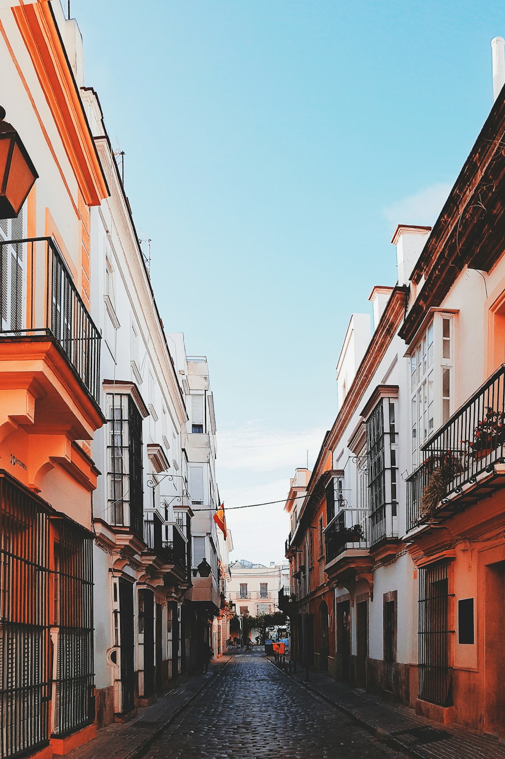 alley surrounded by orange and white concrete buildings