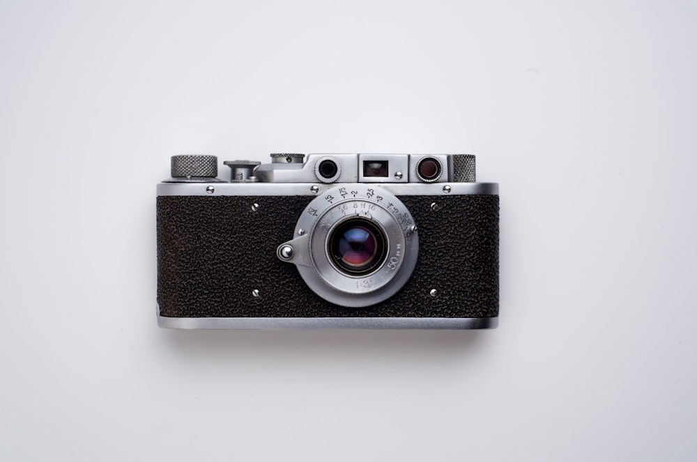 fotocamera reflex nera e grigia su sfondo bianco