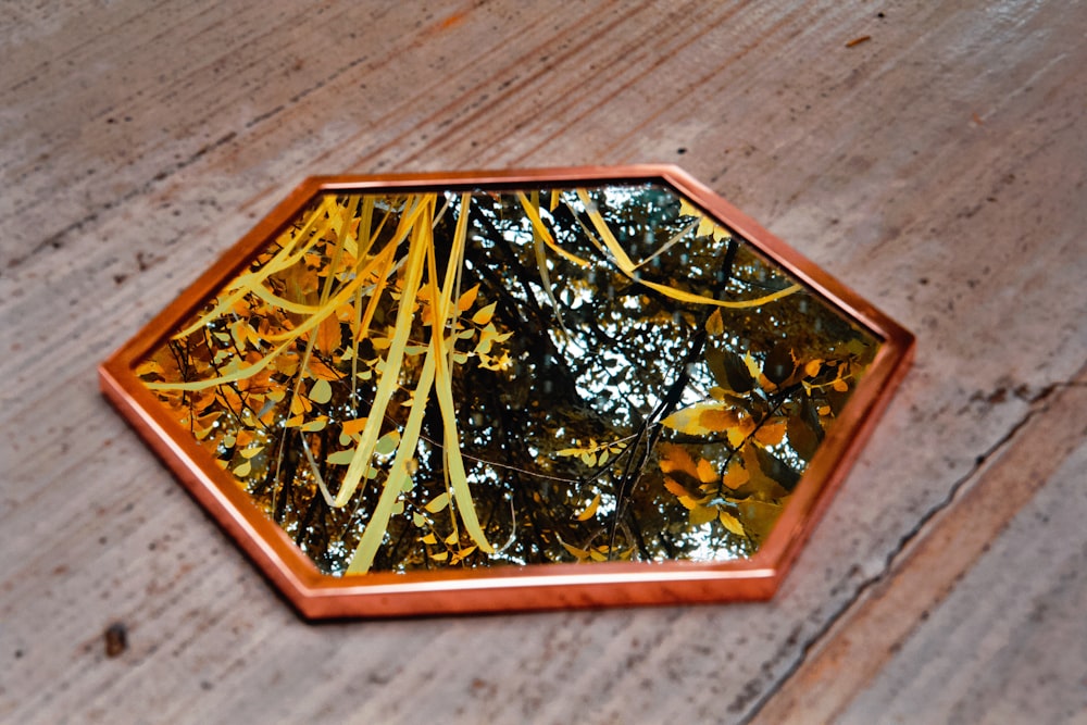 hexagonal brown wooden framed mirror on floor