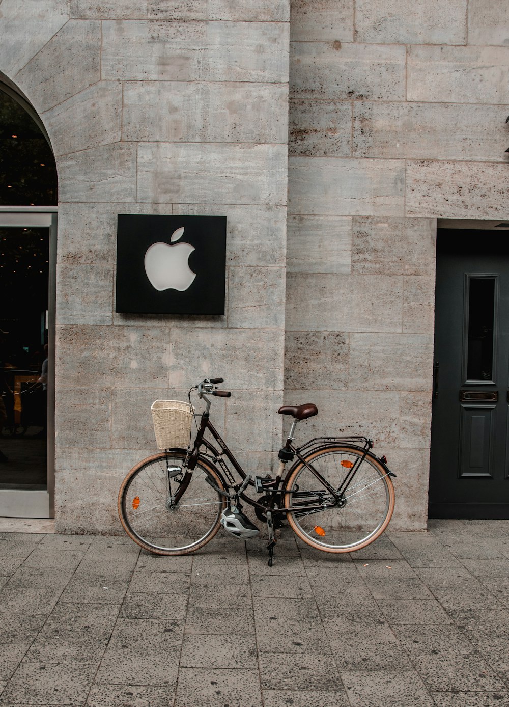 black commuter bicycle parked beside building