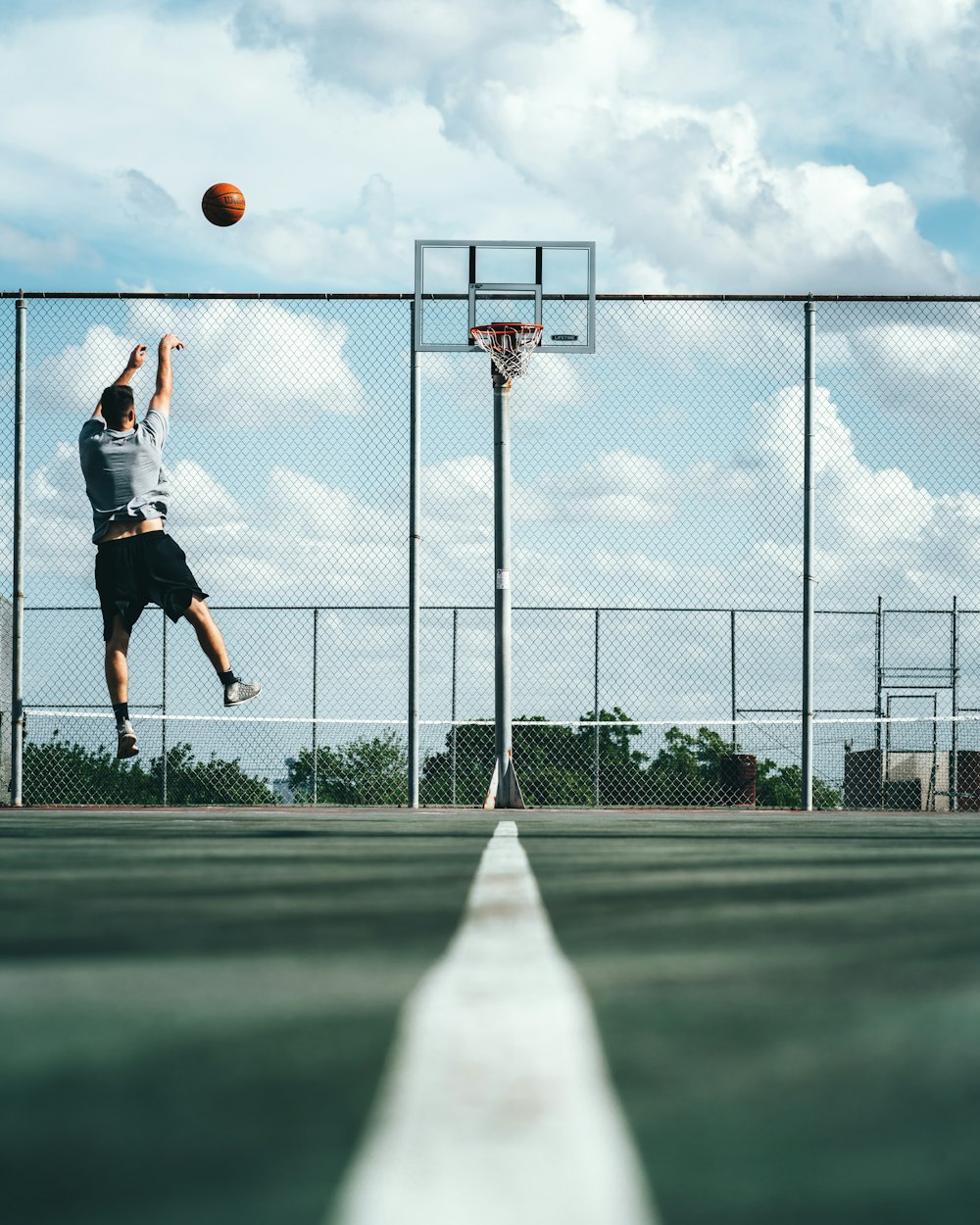 man shooting ball on basketball hoop
