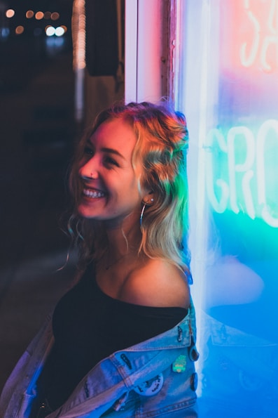 woman leaning on neon signage