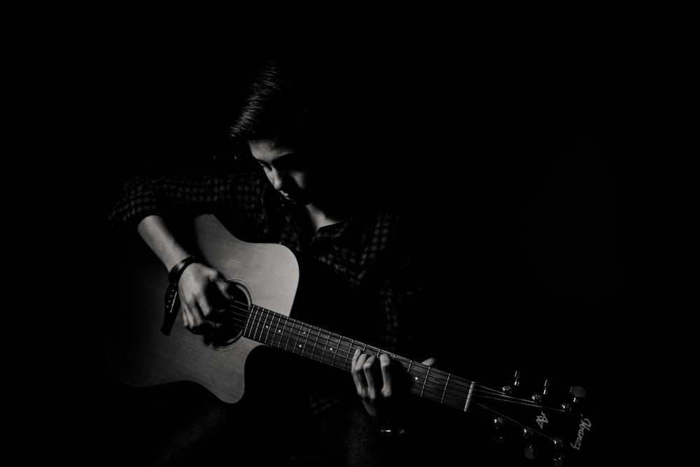 man playing guitar on black background