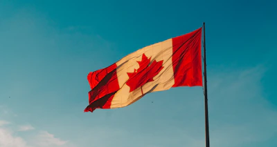 Canadian flag displayed proudly against a clear blue sky.