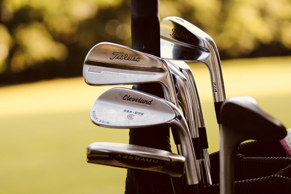 A set of forged irons standing in a leather golf bag