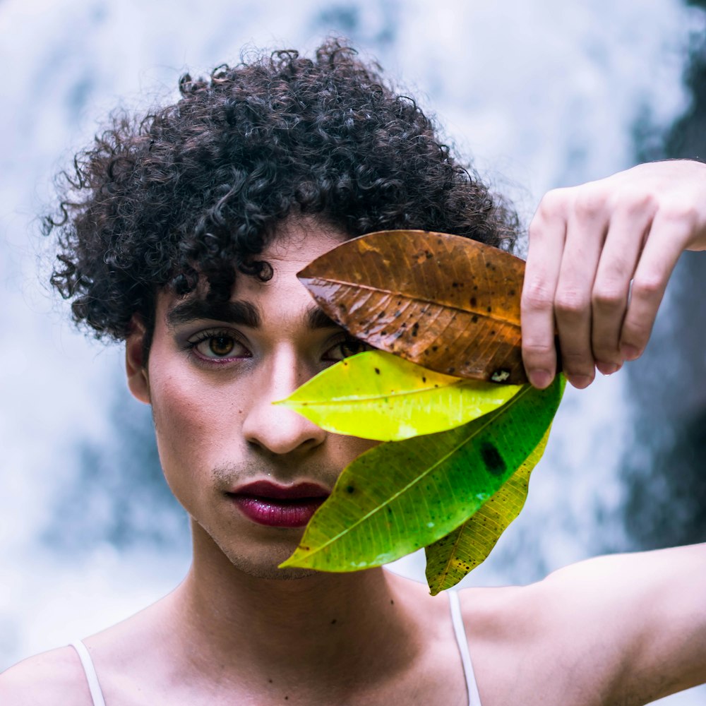 man holding three leaves