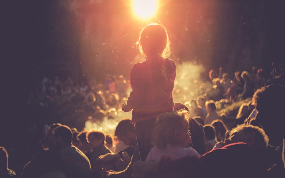 girl standing surrounded by people during nightstand