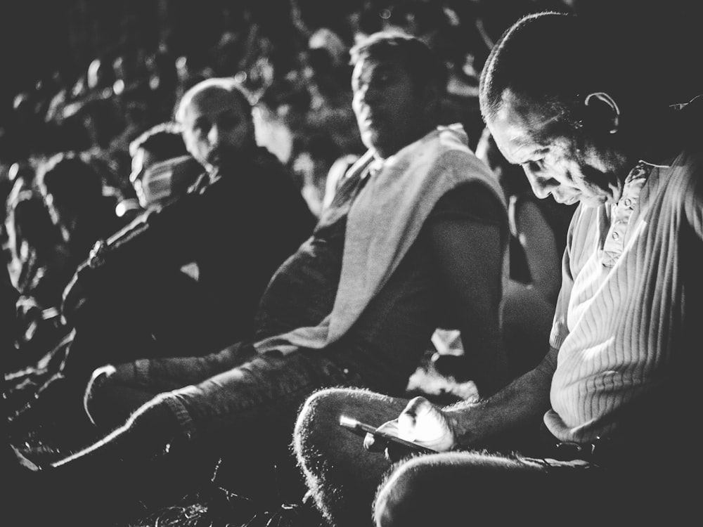 grayscale photography of man holding smartphone