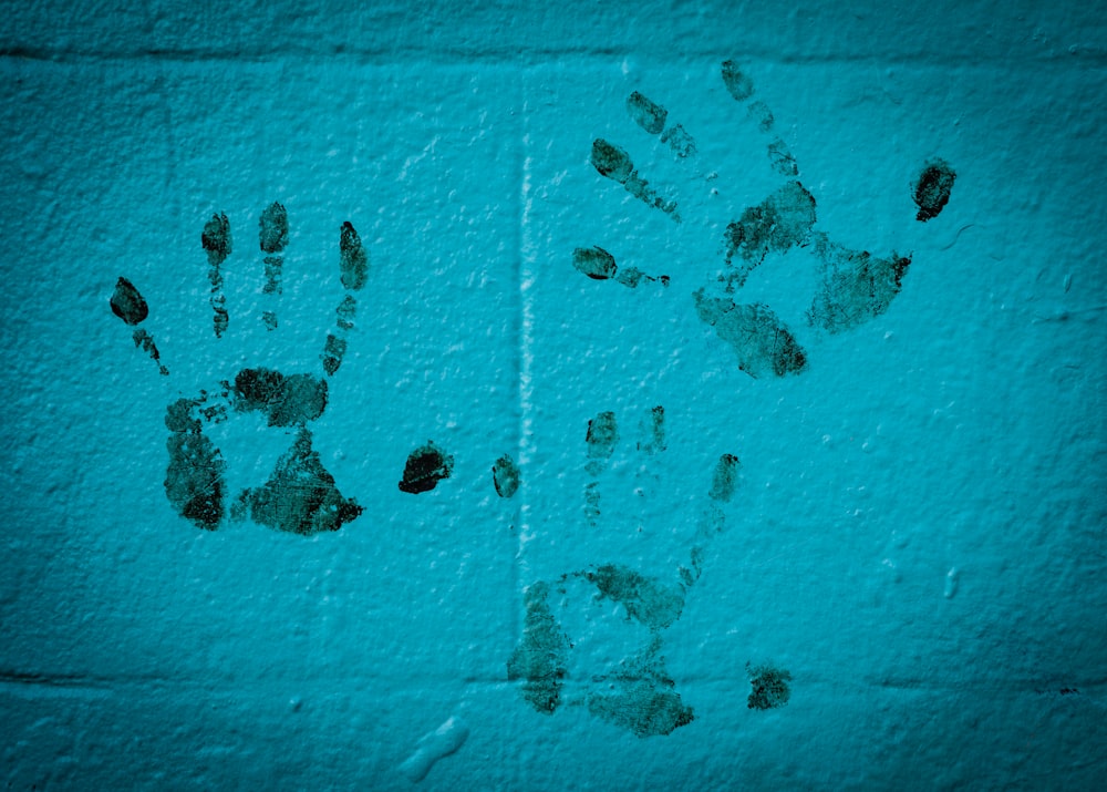 three hand prints on white wall