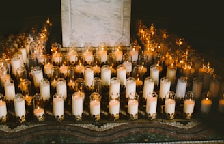 Cream-colored candles flickering gently on a marble surface with hints of gold accents