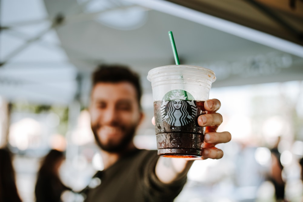 man holding Starbucks cup