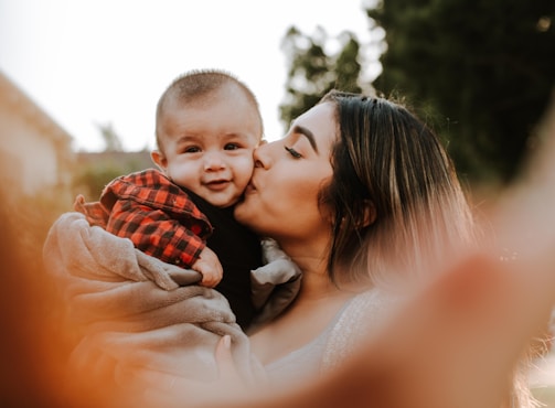 woman kiss a baby while taking picture