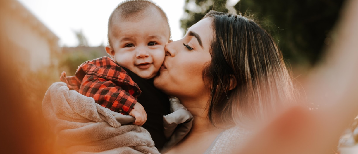 woman kiss a baby while taking picture