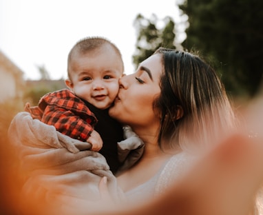 woman kiss a baby while taking picture